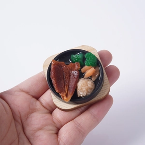 Miniature iron plate beef steak model keychain held by hand on white background