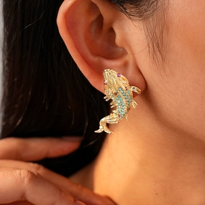 Macro detail of carp earring with colorful zircons worn on model earlobe