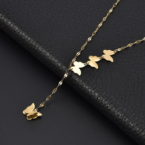 Polished gold butterfly pendant necklace on a premium black leather background