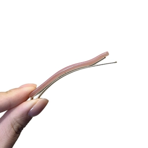 Handheld view of a wavy Morandi pink-brown hair clip with metal duckbill base
