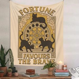 Close-up of bohemian wall tapestry with black cat, moon phases and zodiac motifs on a beige background