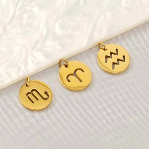 Detailed view of three golden circular stainless steel hollow zodiac charm pendants