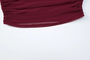 Détail du tissu en maille bordeaux avec des plis élégants et des coutures précises