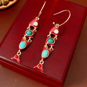 Détail des boucles d'oreilles poisson vintage en émail rouge avec pierres précieuses colorées