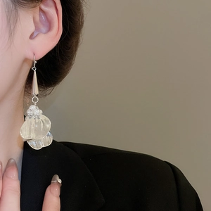 Close-up of translucent white petal earrings with pearls on a silver-tone long drop hook