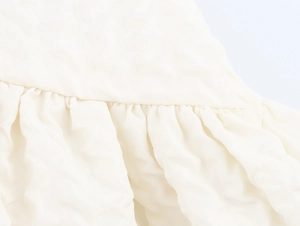 Gros plan sur la texture élégante du tissu blanc avec des détails plissés et drapés