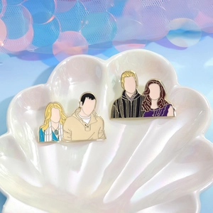Cartoon character enamel pin set in decorative shell tray with glitter background