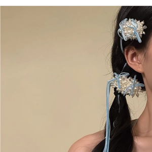 Vue détaillée d'une barrette en perles blanches avec ruban en velours bleu clair