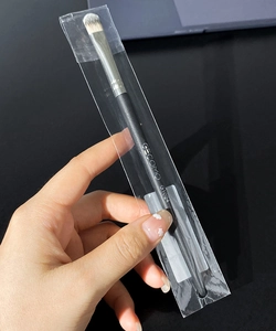 Close-up of GECOMO G1024 round concealer brush with black handle in transparent bag