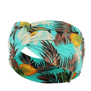 Detail of turquoise sports headband with tropical leaves, pineapple print and knotted design