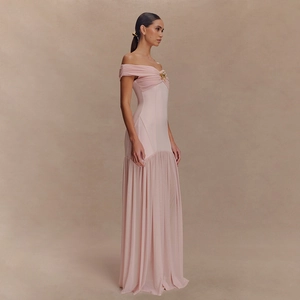 Detail eines eleganten rosa trägerlosen Maxikleides aus Netzstoff mit goldener Brosche