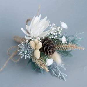 Forest style wedding boutonniere featuring white flowers, pine cones and rustic burlap twine