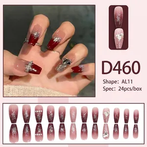 Macro view of gradient red press-on nails with silver glitter and heart rhinestones