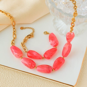 Detail of gold chain necklace and bracelet with pink irregular faux stone beads