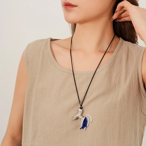 Détail du pendentif cheval argenté avec perles bleues et blanches sur cordon ciré long