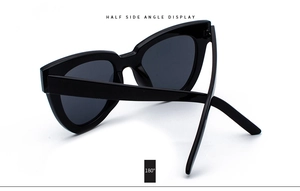 Detail view of black cat-eye sunglasses with 180-degree flexible temples on white background