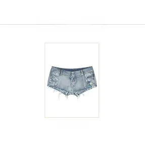Dettaglio degli hot pants in denim blu con fori distressed e bordi con frange