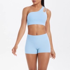 Detail of light blue one-shoulder sports bra and high-waist shorts set on a model