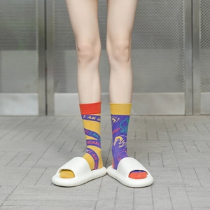 Detail view of asymmetric crew socks featuring contrasting colors and I AM GREAT text print