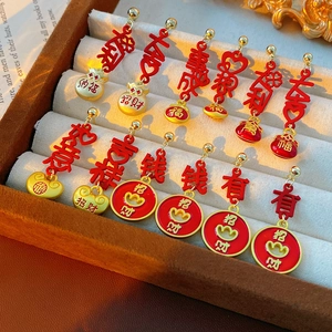 Macro shot of vintage enamel fortune bag earrings with gold tassels in a velvet box