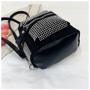 Detalle de mochila negra con adornos de diamantes de imitación y base de cuero sintético