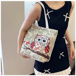 Detail of ethnic canvas tote bag featuring colorful owl pattern and jacquard texture