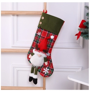 Detail of red and green plaid Christmas stocking featuring a 3D gnome doll with white beard