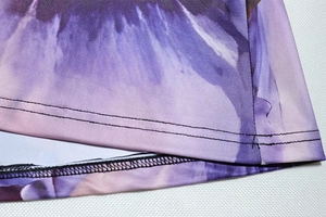 Detailed macro view of high-quality double-needle hem on purple digital print fabric