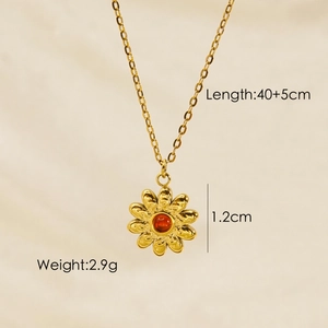 Detailed close-up of golden daisy pendant with red agate inlay and product dimensions