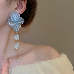 Macro detail of blue acrylic flower petal earrings with long tassel pendant and chain