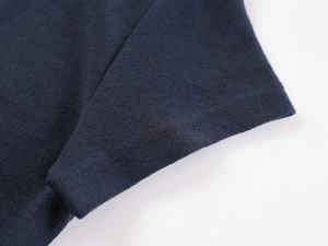 Macro shot of dark blue knitted fabric texture and fine stitching on the polo shirt