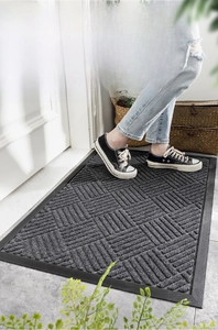 Close-up of deep grey door mat showing geometric textured surface and rubber edge