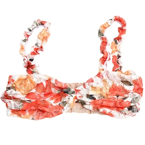 Detail of red floral bikini top with ruffle straps and front twist knot on white background