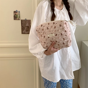 Détail de la trousse de maquillage rose matelassée avec motifs d'ours et fermeture éclair