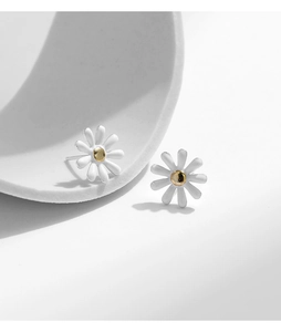 Macro view of S925 silver daisy stud earrings with white petals and gold flower center