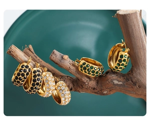 Macro detail of vintage gold-plated C-shaped earrings with inlaid colorful crystals