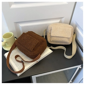 Brown and beige faux fur crossbody bags with fabric straps on a minimalist table
