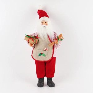 Standing Santa Claus doll in red striped shirt and apron holding gift box and utensils