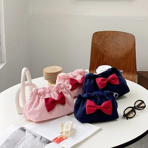 Detail of velvet makeup bag with red bow, rabbit pattern and ball clasp closure