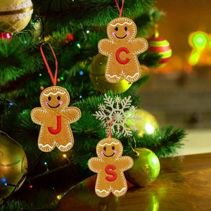 Brown gingerbread man felt ornament with red letter embroidery hanging on a Christmas tree