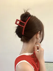 Detail of red matte geometric hair claw clip on model showing a refined back hairstyles
