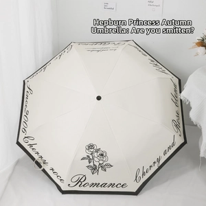 Detail of cream-colored umbrella fabric with vintage black rose and romance calligraphy