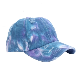 Dettaglio del cappello da baseball in denim tie-dye invecchiato con bordo sfrangiato blu e viola