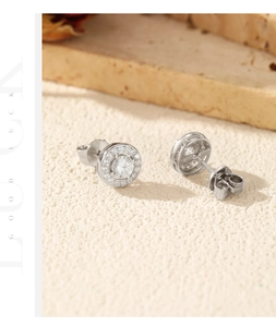 Macro shot of silver Moissanite stud earrings with halo diamonds and butterfly backs