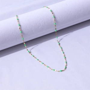 Detail of 18k gold plated stainless steel chain with vibrant green enamel beads