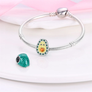 Detailed view of silver charm bracelet with green enamel avocado and orange heart core