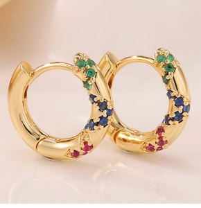 Detailed shot of gold hoop earrings with green, blue, and pink cubic zirconia stones