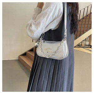 Detail of silver crossbody bag featuring metallic texture and star-shaped decoration