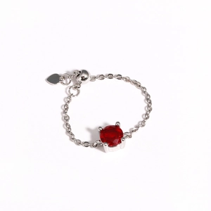Detailed close-up of a silver chain ring featuring a large red circular cubic zirconia