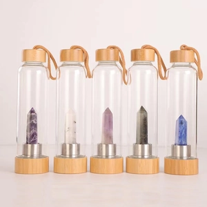 Detailed row of glass energy water bottles with bamboo lids and various crystal points